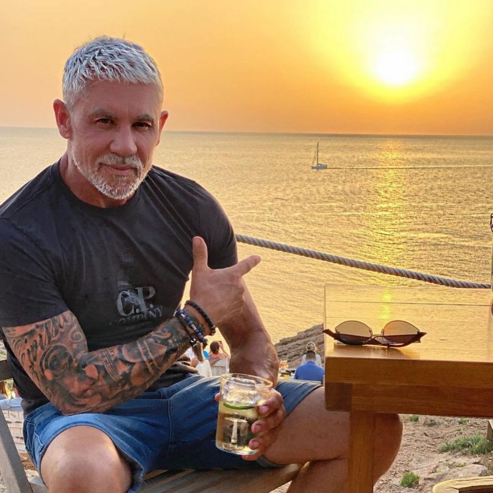 a man wearing a c.p. company shirt sits at a table