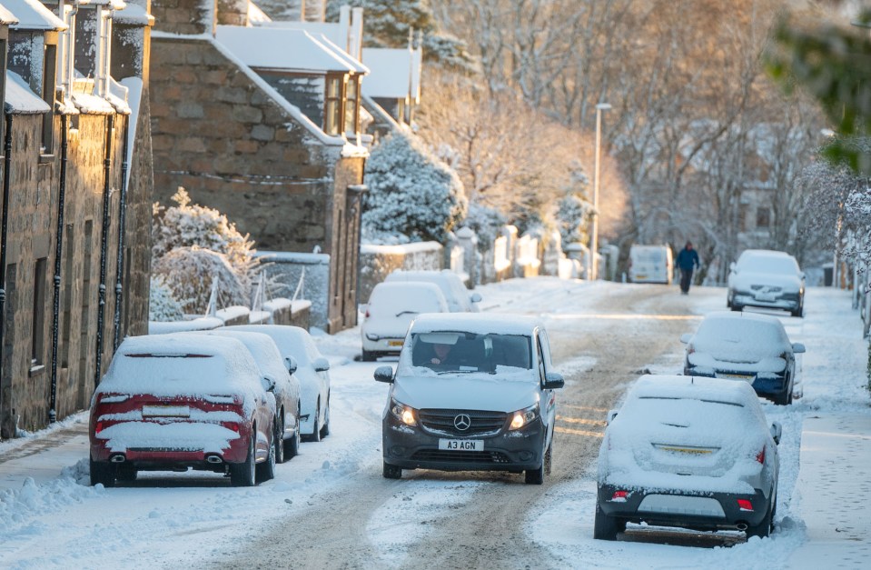 a mercedes van is driving down a snowy street