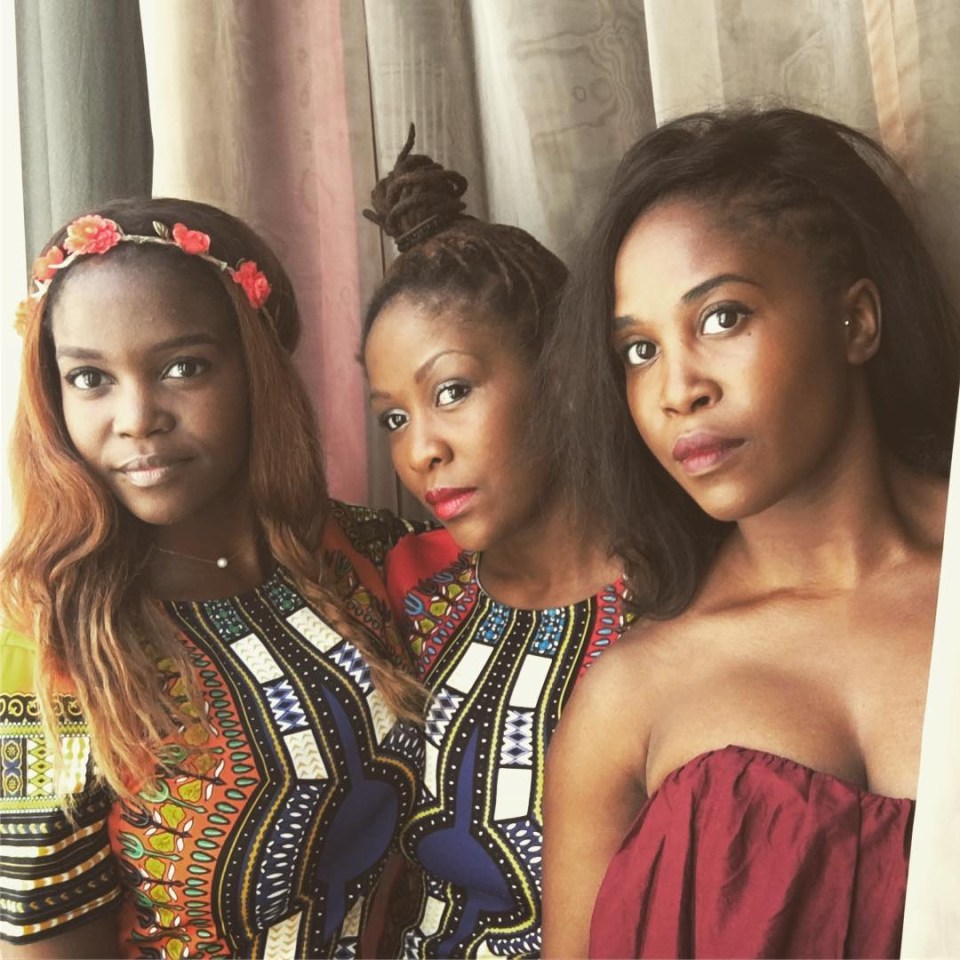 three women standing next to each other with one wearing a floral headband