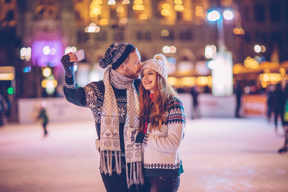 a man is taking a picture of his girlfriend with his phone