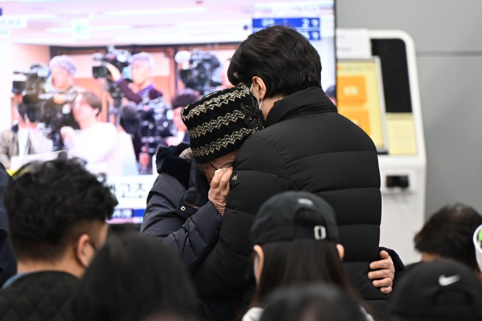 Relatives of victims grieve at an airport following a plane crash.