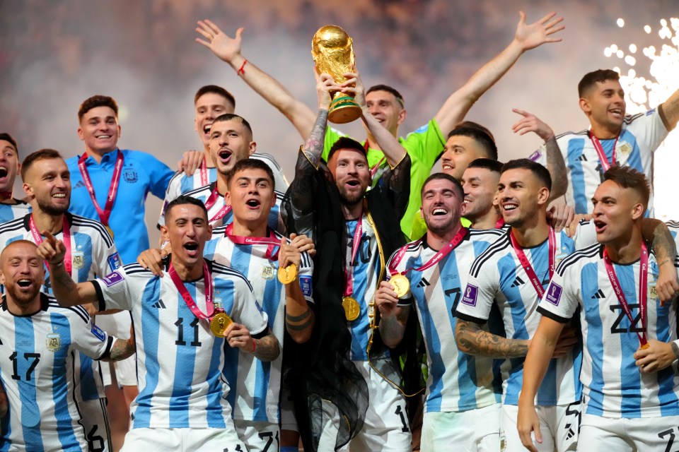 Argentina's Lionel Messi lifts the World Cup trophy with his team.