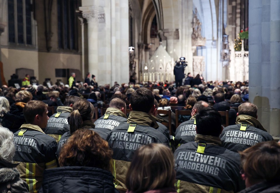 Firefighters at a memorial service in Magdeburg Cathedral following a vehicle-ramming attack at a Christmas market.