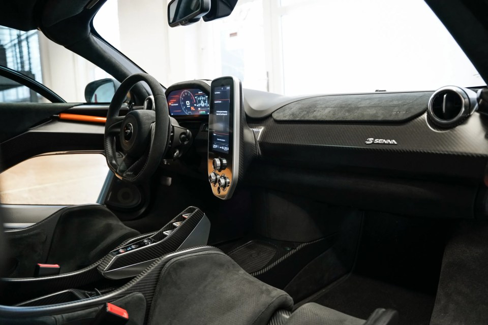 Interior view of a McLaren Senna XP, showing the dashboard, steering wheel, and seats.