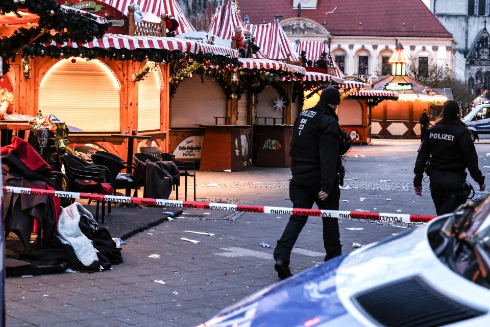 Police officers at a cordoned-off Christmas market after a vehicle-ramming attack.