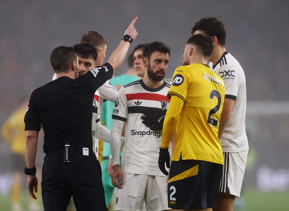 Bruno Fernandes of Manchester United is consoled by a teammate after a red card.