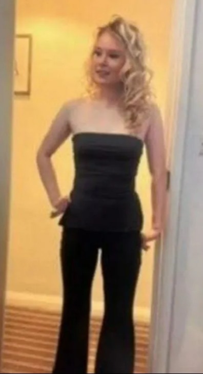 Girl in black strapless top and bell-bottom pants.