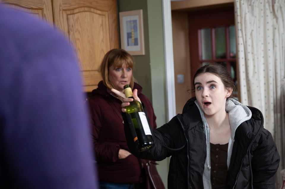 Emmerdale scene: April Windsor confronts Marlon Dingle with a bottle of wine.