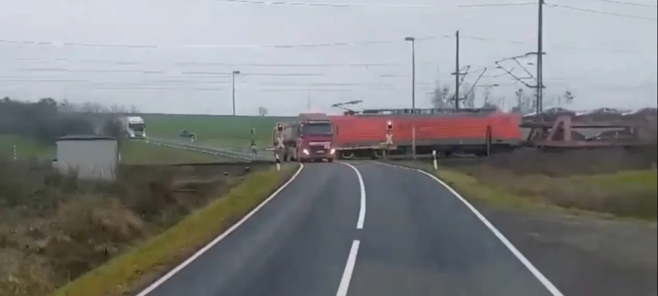 Train narrowly misses truck at a level crossing.