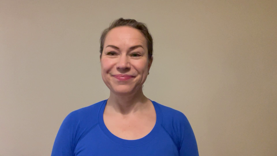 Woman in blue shirt smiling at camera.