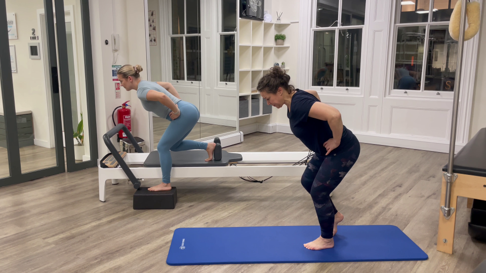 Two women performing Pilates exercises at home.