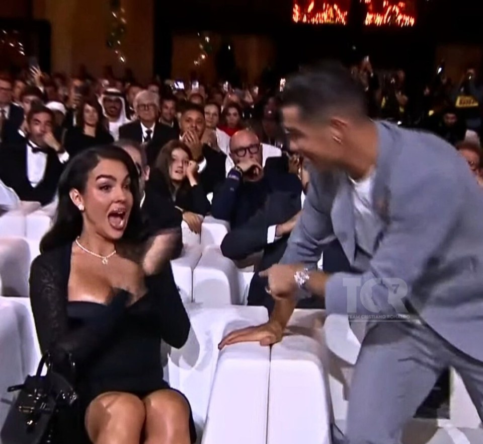 Cristiano Ronaldo laughing and playfully interacting with a surprised woman in an audience.