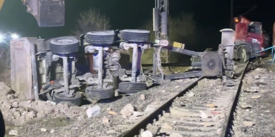 A wrecked truck on a railroad track.