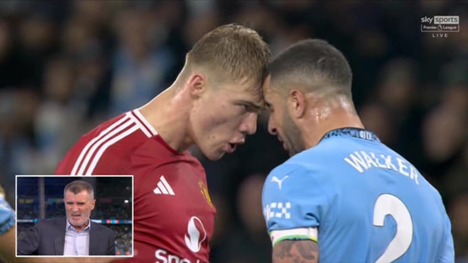 Two soccer players face off, heads close together.