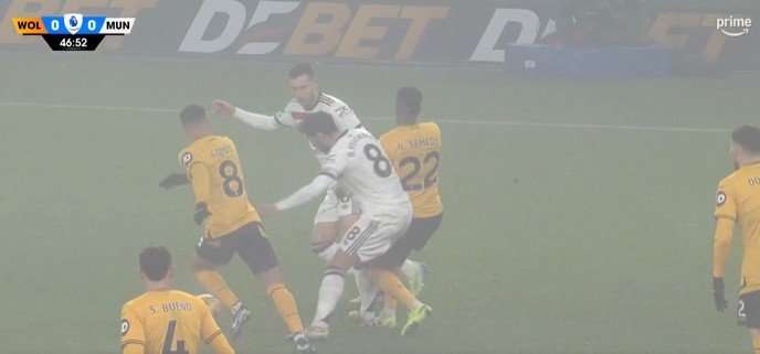 Soccer players in a foggy game.
