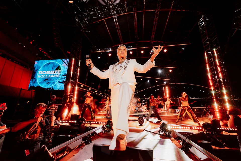 Robbie Williams performing on stage.