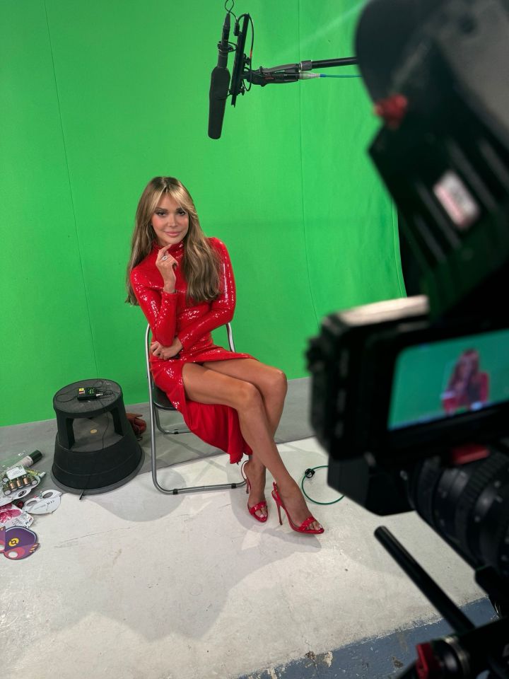 Woman in red dress being interviewed on a green screen.