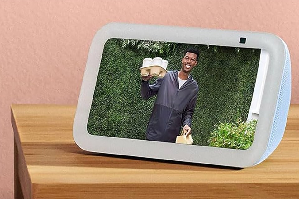 Smart display showing a delivery person holding several cups of coffee.