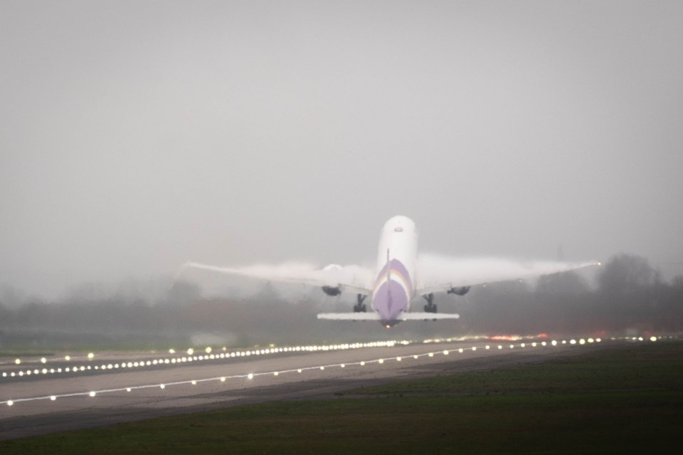 Thai Airways Boeing 777-300ER taking off in foggy conditions.