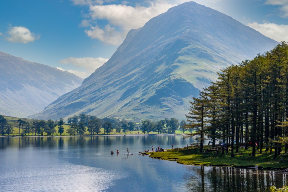 Lake Buttermere in the English Lake District, surrounded by mountains and trees.
