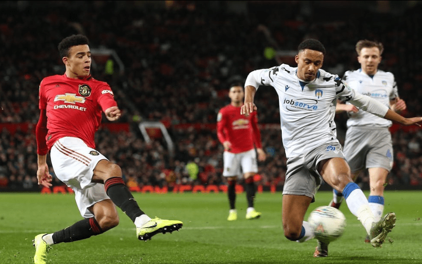 Manchester United player tackling opponent.
