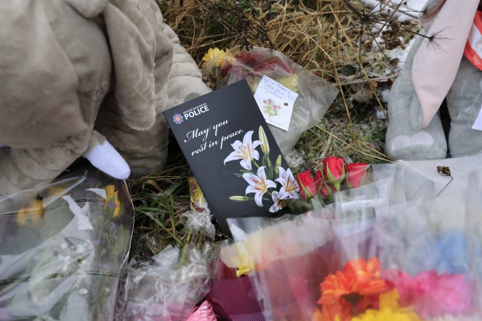 Floral tributes and a memorial card at a site where a baby's remains were found.