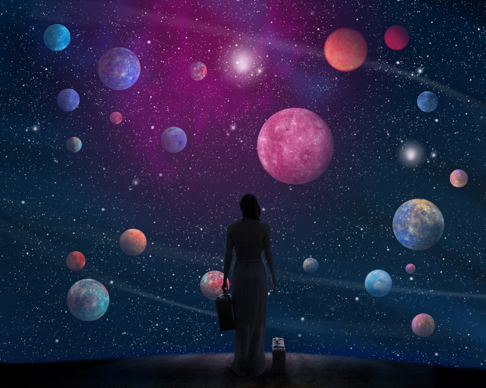 Woman with suitcases contemplates a starry sky filled with planets.