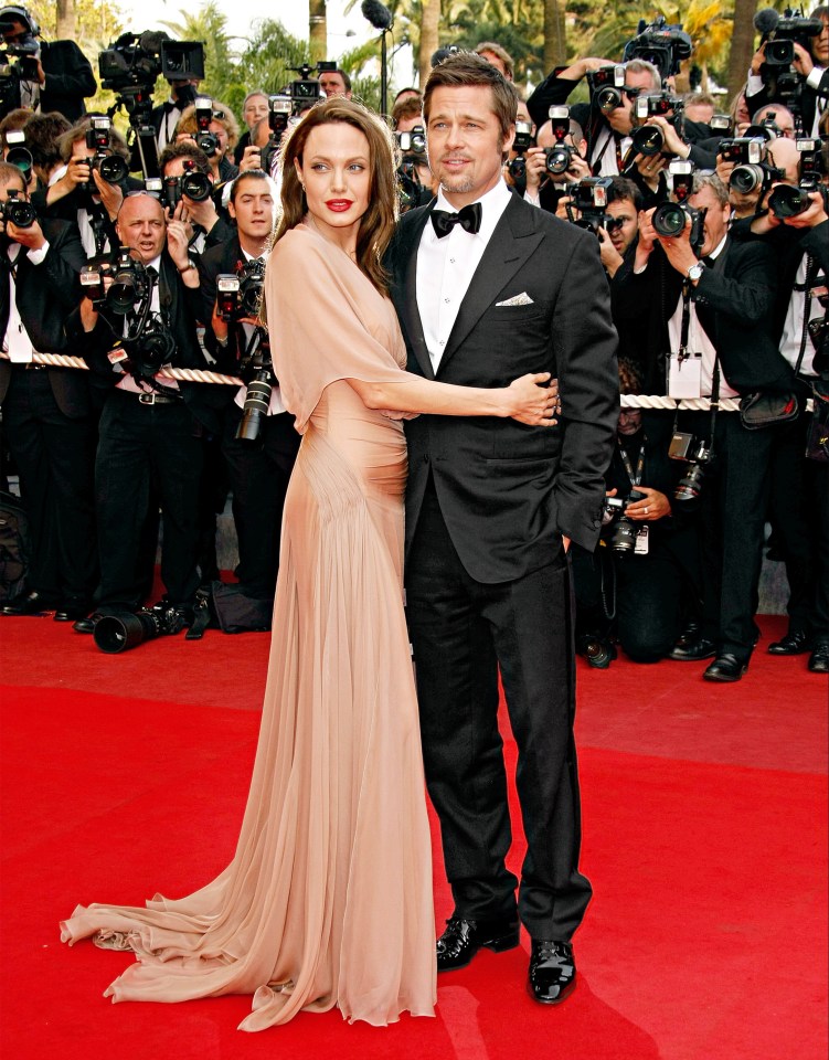a man and woman are posing for a picture on a red carpet