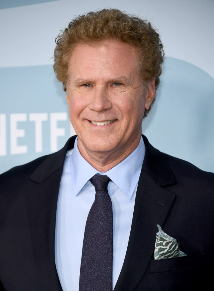 Comedian Will Ferrell, wearing a black suit, poses for a photo on a red carpet in front of a movie poster.