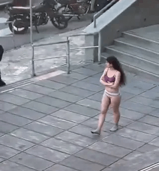 Woman in underwear walking outdoors.
