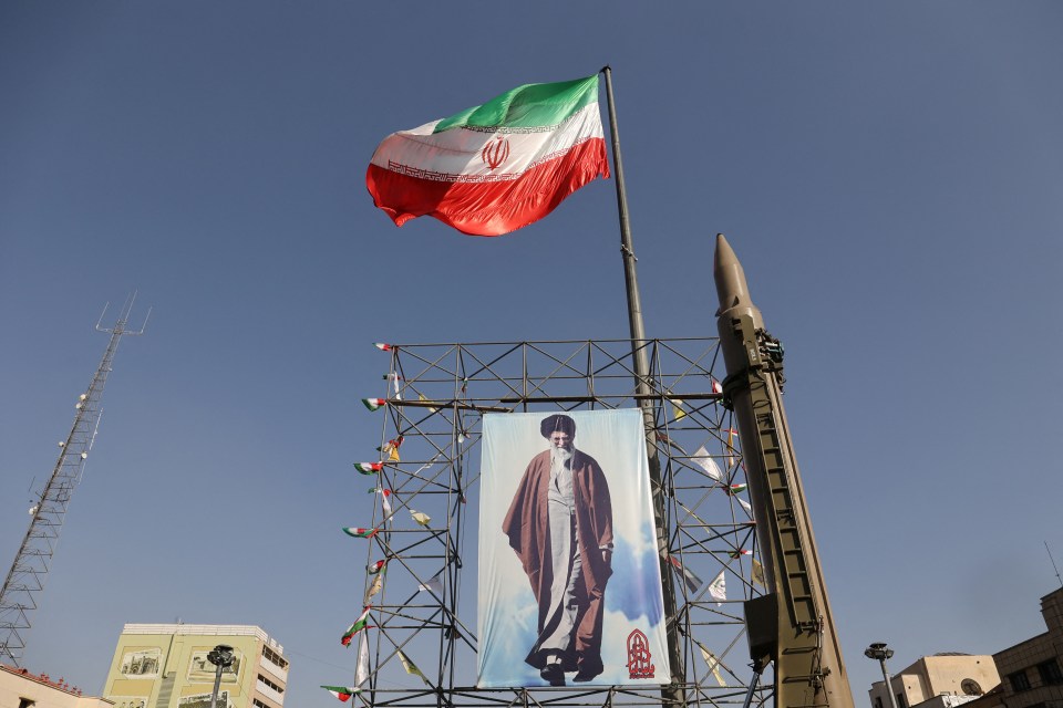 An Iranian missile system is displayed next to a banner with a picture of Iran's Supreme Leader Ayatollah Ali Khamenei in Tehran