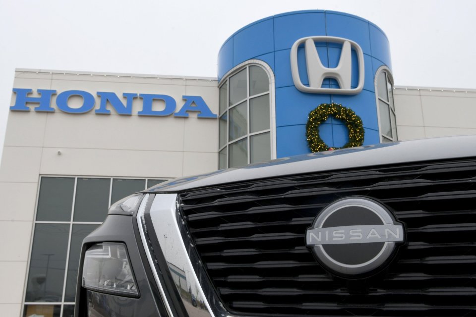 A Nissan Rogue SUV in front of a Honda dealership.