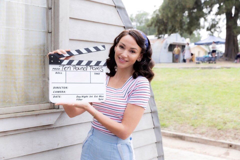 Michelle Keegan holding a clapperboard for Ten Pound Poms.