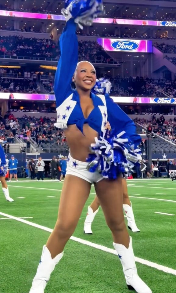 A Dallas Cowboys cheerleader performs a routine without a wig.