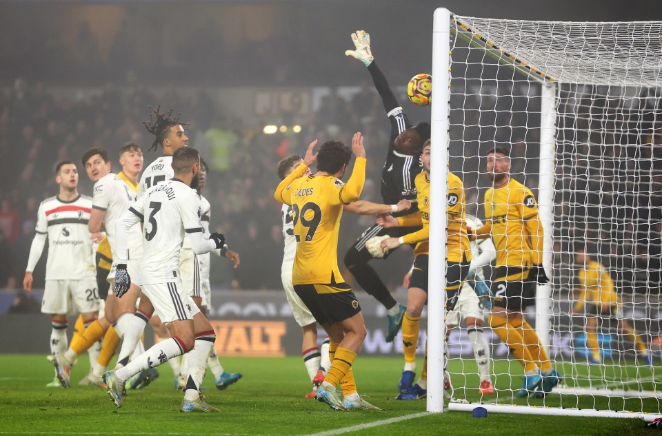 Soccer goal with a goalkeeper attempting to save a goal.