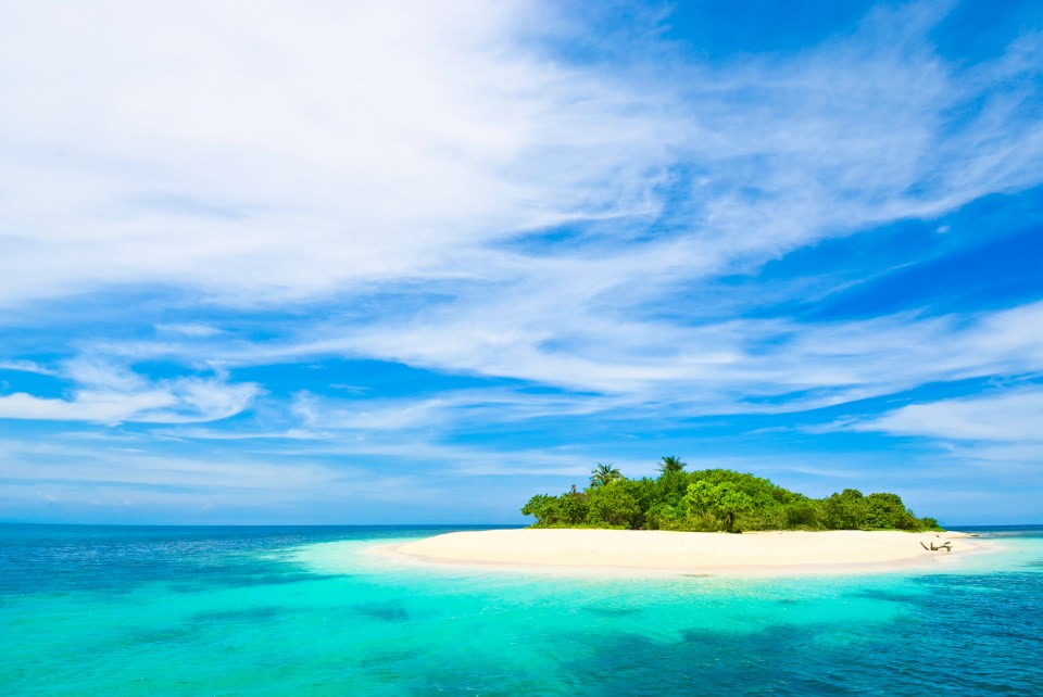 Tropical island with turquoise water and white sand beach.