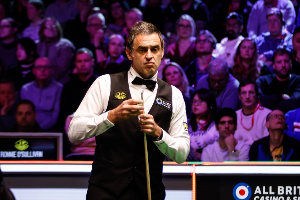 Ronnie O'Sullivan chalking his cue at a snooker match.