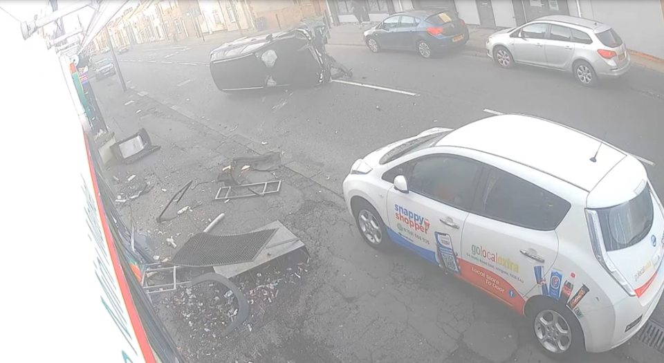Car crash scene with overturned vehicle and debris.