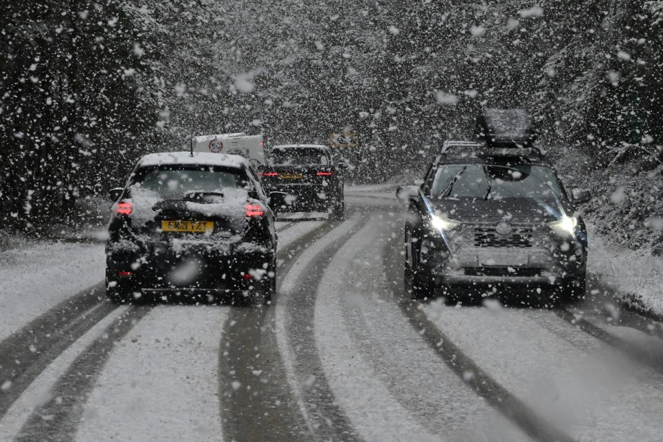 Cars driving on a snowy road.