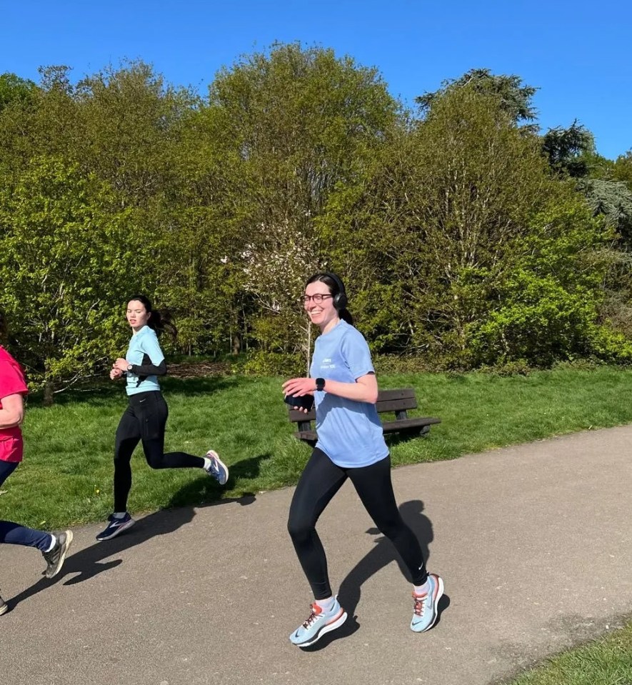 a group of people are running on a path in a park