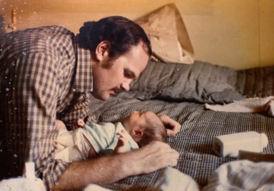A father gazing at his newborn baby daughter.