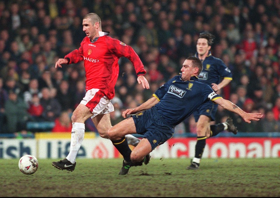 Eric Cantona of Manchester United avoids a tackle by Vinnie Jones of Wimbledon during an FA Cup match.
