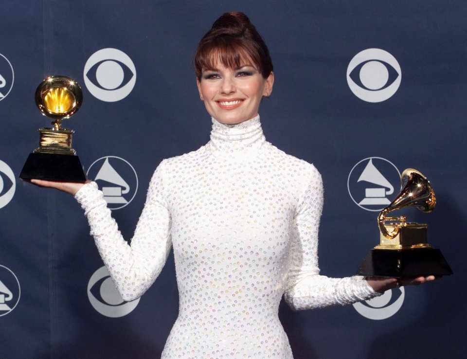 Shania Twain holding two Grammy Awards.