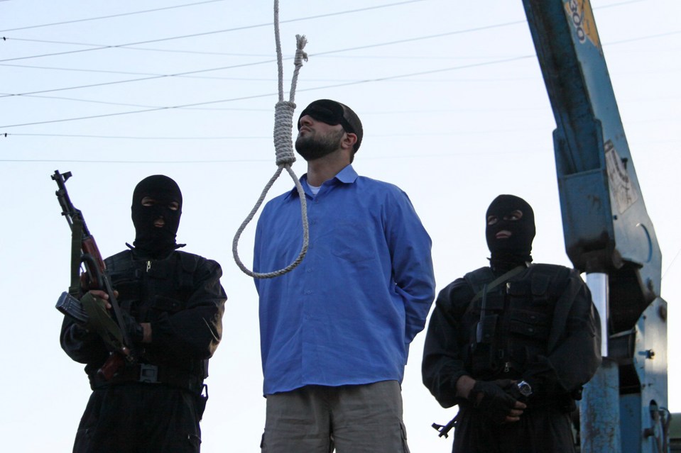 A blindfolded man about to be publicly hanged for armed robbery, kidnapping, and killing two police officers.