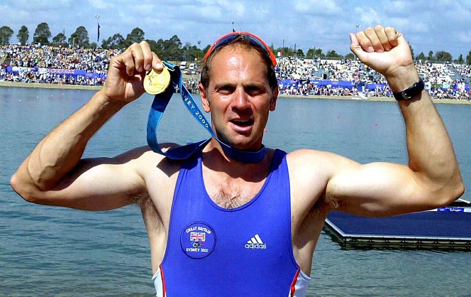 Steve Redgrave holding up his gold medal at the Sydney 2000 Olympics.