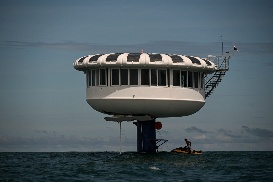 SeaPod Alpha Deep, an underwater living structure, with a person on a jet ski nearby.