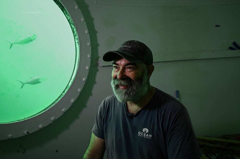 Rudiger Koch, underwater in a room, being interviewed.