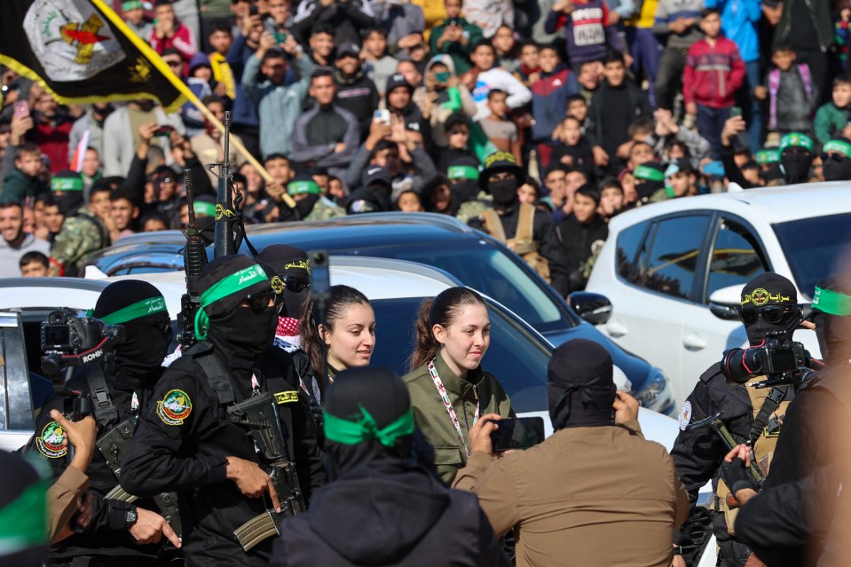 Hamas militants handing over Israeli hostages to the Red Cross.