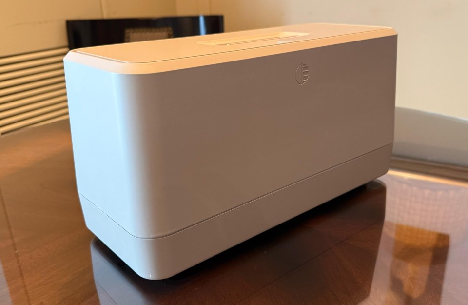 Light beige rectangular device on a wooden table.