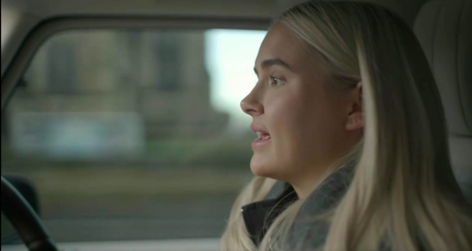 Screenshot of a blonde woman speaking while driving a car.